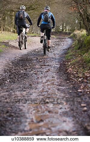 Couple mountain biking in countryside View Large Photo Image Stock Photo - Couple mountain biking in countryside. Fotosearch