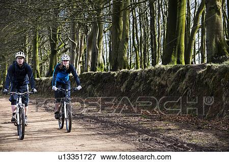 Couple mountain biking in countryside View Large Photo Image Stock Photo - Couple mountain biking in countryside. Fotosearch