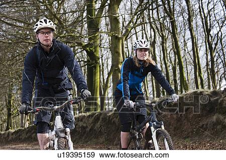 Stock Photo - Couple mountain biking in countryside. Fotosearch