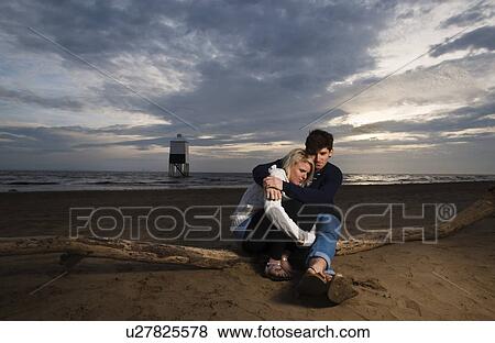 Stock Photo - Couple on beach at sunset. Fotosearch