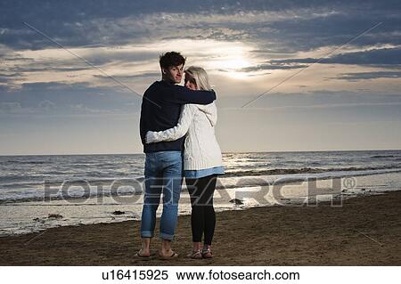 Stock Photography - Couple on beach at sunset. Fotosearch