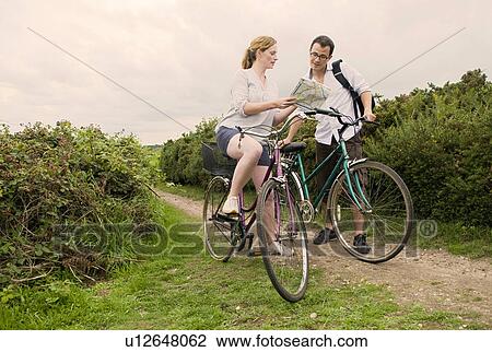 Stock Image - Couple on bicycle trip check route. Fotosearch
