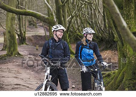Couple on mountain bikes in woods View Large Photo Image Stock Photography - Couple on mountain bikes in woods. Fotosearch