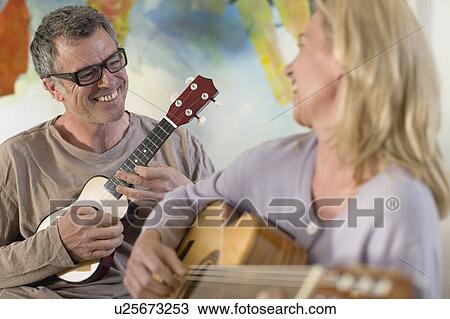 Stock Image - Couple playing guitar and ukulele. Fotosearch