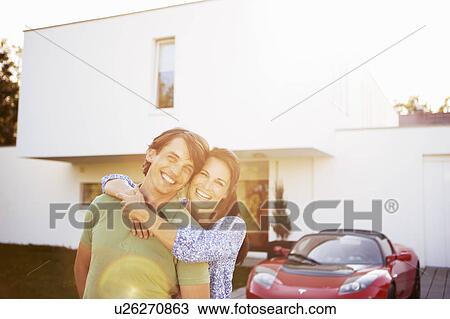 Couple posing in front of house and car View Large Photo Image Stock Image - Couple posing in front of house and car. Fotosearch