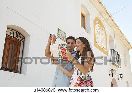 Couple reading guidebook by old church View Large Photo Image Stock Image - Couple reading guidebook by old church. Fotosearch