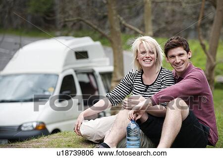 Stock Photograph - Couple relaxing with mobile home. Fotosearch