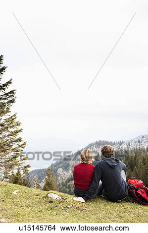 Picture - Couple resting on mountain. Fotosearch