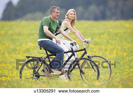 Couple riding bikes View Large Photo Image Stock Image - Couple riding bikes. Fotosearch