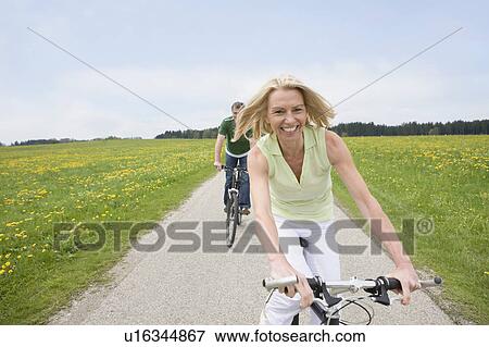 Couple riding bikes View Large Photo Image Stock Photo - Couple riding bikes. Fotosearch