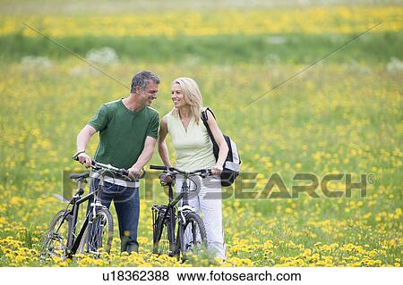 Couple riding bikes View Large Photo Image Stock Photo - Couple riding bikes. Fotosearch