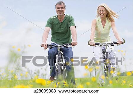 Couple riding bikes View Large Photo Image Stock Photo - Couple riding bikes. Fotosearch