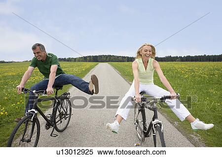 Couple riding bikes View Large Photo Image Stock Photography - Couple riding bikes. Fotosearch