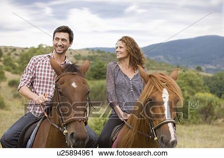 Couple riding horses View Large Photo Image Stock Image - Couple riding horses. Fotosearch