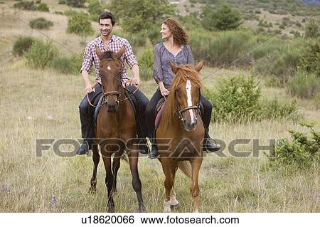 Couple riding horses View Large Photo Image Stock Photograph - Couple riding horses. Fotosearch