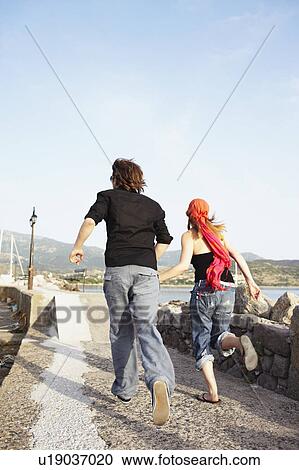 Stock Image - Couple running away. Fotosearch