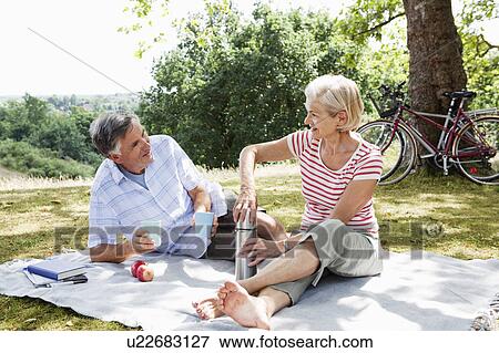 Stock Photo - Couple sharing picnic. Fotosearch