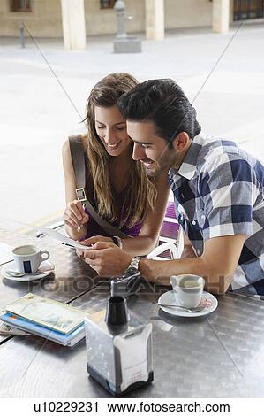 Stock Image - Couple sharing postcard in cafe. Fotosearch