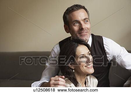 Stock Photo - Couple sitting on couch. Fotosearch