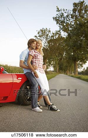 Couple sitting on electric sports car View Large Photo Image Stock Photo - Couple sitting on electric sports car. Fotosearch
