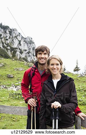 Stock Photo - Couple standing in front of fence. Fotosearch