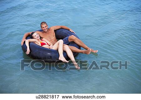 Couple swimming at the beach View Large Photo Image Stock Photo - Couple swimming at the beach. Fotosearch
