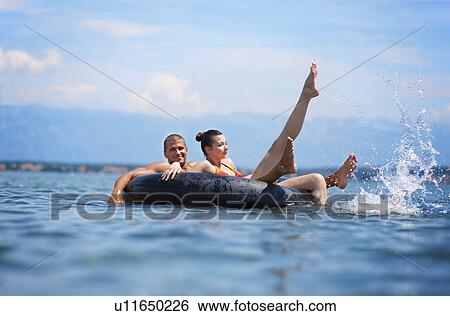 Couple swimming at the beach View Large Photo Image Stock Photograph - Couple swimming at the beach. Fotosearch