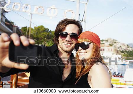 Couple taking picture in front of harbor View Large Photo Image Stock Image - Couple taking picture in front of harbor. Fotosearch