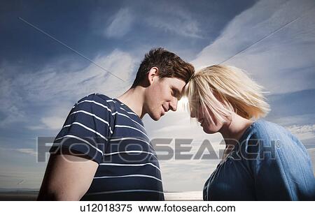 Couple touching heads View Large Photo Image Stock Photography - Couple touching heads. Fotosearch