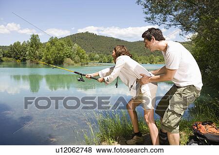 Stock Photo - Couple trying to catch a fish. Fotosearch