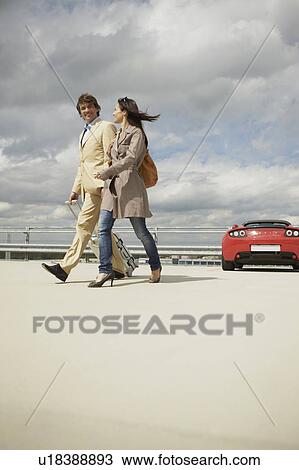 Couple walking on park deck with trolley View Large Photo Image Stock Image - Couple walking on park deck with trolley. Fotosearch