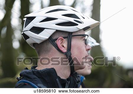 Stock Image - Couple with bike helmets in countryside. Fotosearch