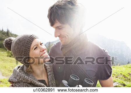 Stock Image - Couple with binoculars on mountain. Fotosearch