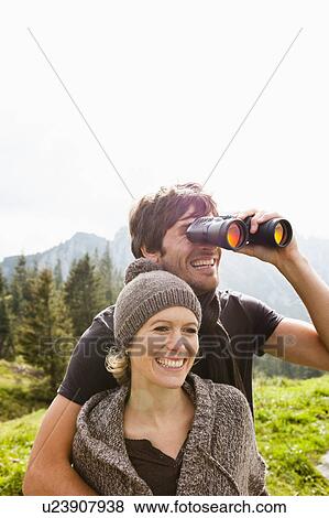 Couple with binoculars watching scenery View Large Photo Image Stock Photo - Couple with binoculars watching scenery. Fotosearch