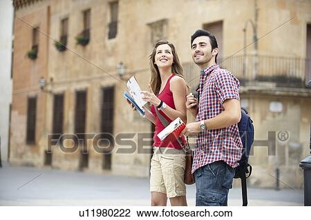 Couple with guidebooks in city square View Large Photo Image Stock Image - Couple with guidebooks in city square. Fotosearch