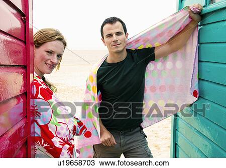 Couple with towels relax by beach huts View Large Photo Image Stock Image - Couple with towels relax by beach huts. Fotosearch