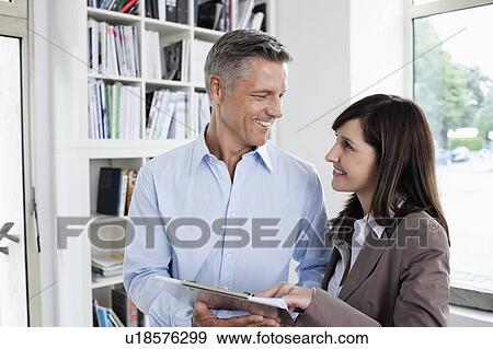 Coworkers discussing paper View Large Photo Image Stock Photo - Coworkers discussing paper. Fotosearch