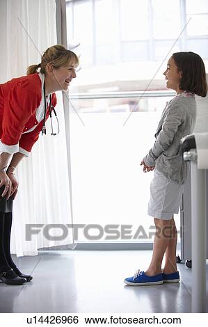 Doctor and young girl laughing View Large Photo Image Stock Photograph - Doctor and young girl laughing. Fotosearch