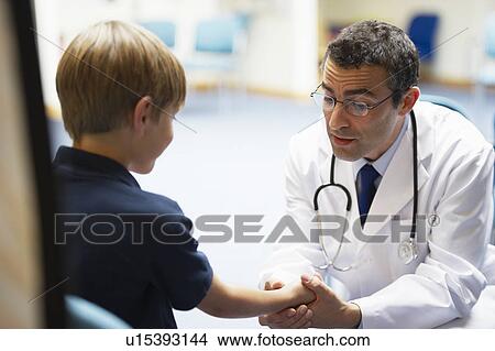 Doctor examining young boy View Large Photo Image Picture - Doctor examining young boy. Fotosearch