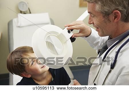 Doctor examining young boy View Large Photo Image Stock Image - Doctor examining young boy. Fotosearch