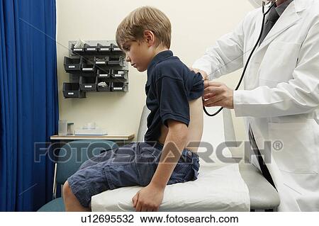 Doctor examining young boy View Large Photo Image Stock Image - Doctor examining young boy. Fotosearch
