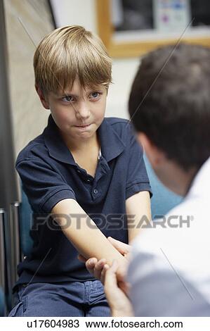 Stock Image - Doctor examining young boy. Fotosearch