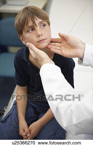 Stock Image - Doctor examining young boy. Fotosearch