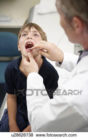 Doctor examining young boy View Large Photo Image Stock Photo - Doctor examining young boy. Fotosearch