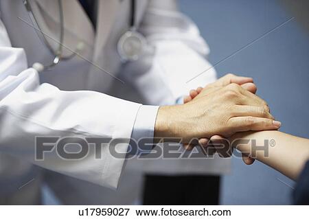 Stock Photo - Doctor holding young boy's hand. Fotosearch