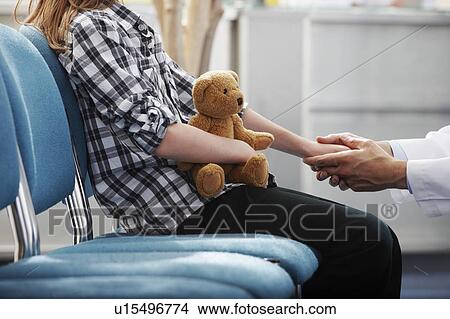 Picture - Doctor holding young girls hand. Fotosearch
