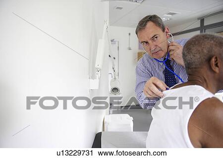 Doctor listening with stethoscope View Large Photo Image Stock Image - Doctor listening with stethoscope. Fotosearch