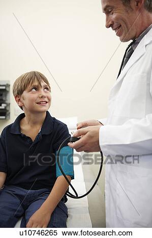 Doctor taking young boy's blood pressure View Large Photo Image Stock Photography - Doctor taking young boy's blood pressure. Fotosearch