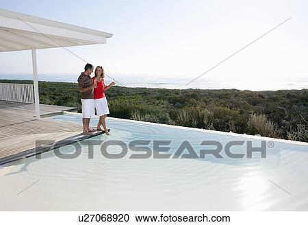Stock Image - Elderly couple by the pool. Fotosearch