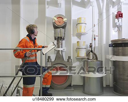 Stock Photo - Engineer checks spare part. Fotosearch